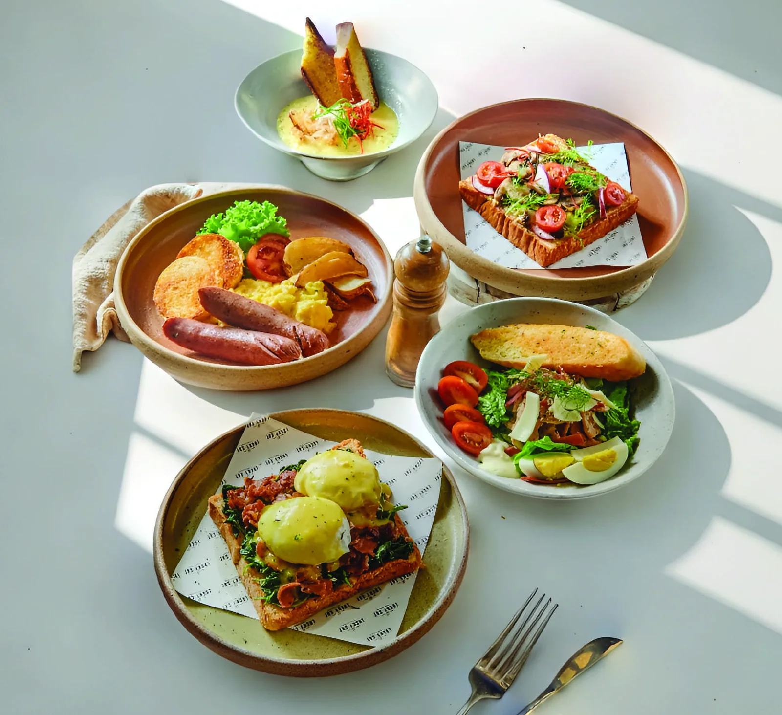 Hidangan brunch Lucky Cat dengan telur, toast dan salad
